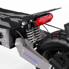 Close-up of a APEFOX T90 Dual Drive Electric motorcycle's rear suspension and tail light with 'Apefox' branding.