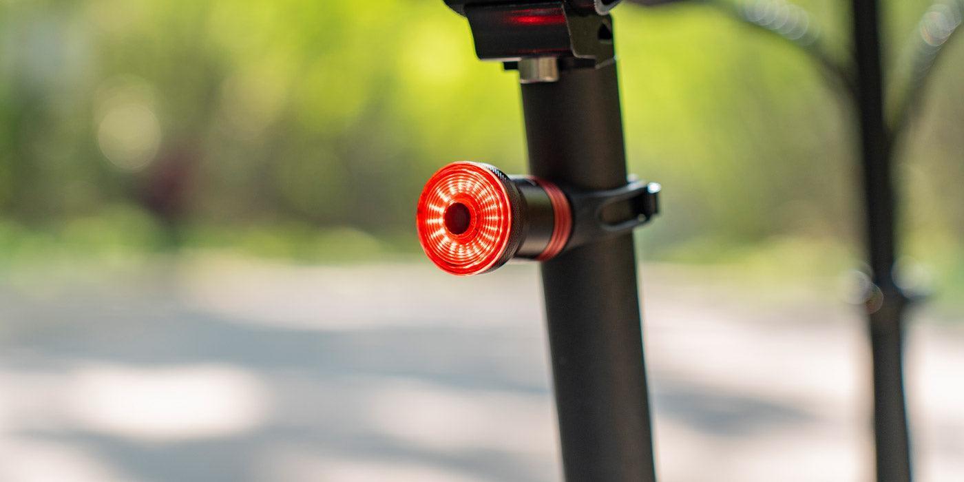 Close-up of electric bike rear LED tail light mounted on seat post outdoors