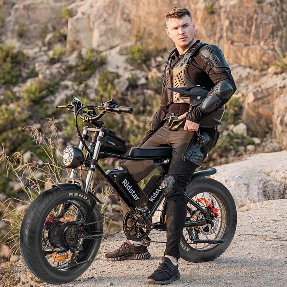Man in protective gear standing next to a black Ridstar Q20 Pro Electric Cargo Bike in a rocky outdoor setting