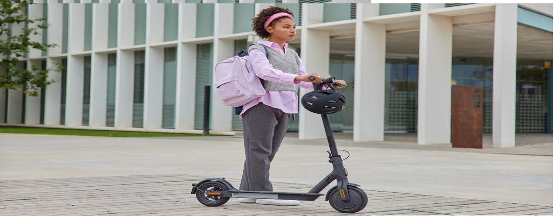Electric scooter in black side view ridden by student outdoors in urban setting