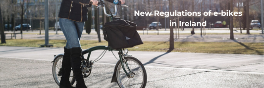 Electric bike with front basket ridden by person on city street, side view