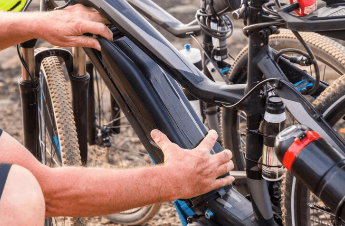 Detail view of electric bike battery being installed on a black e-bike frame