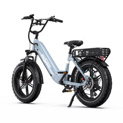 A light blue Onesport OT08 electric fat-tire bicycle with black components, a rear cargo basket, and a kickstand, photographed on a clean white background.